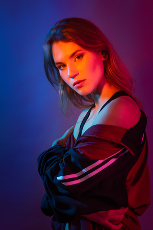 Retro style fashionable woman posing in purple, blue, and pink lights. Fashion back to 80s - 90s new trend conceptの写真素材