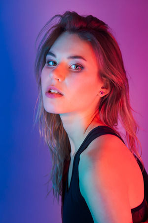 Retro style fashionable woman posing in purple, blue, and pink lights. Fashion back to 80s - 90s new trend conceptの写真素材