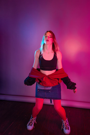 Retro style fashionable woman posing in purple, blue, and pink lights. Fashion back to 80s - 90s new trend conceptの写真素材
