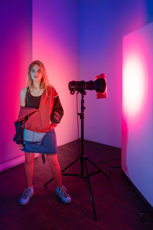 Retro style fashionable woman posing in purple, blue, and pink lights. Fashion back to 80s - 90s new trend conceptの写真素材