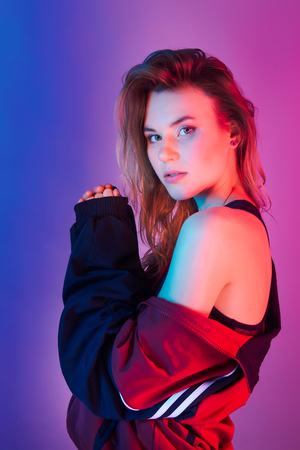 Retro style fashionable woman posing in purple, blue, and pink lights. Fashion back to 80s - 90s new trend conceptの写真素材