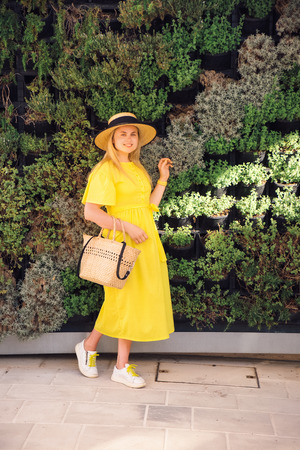 Beautiful blonde woman walking in yellow dress at Paphos old city with colorful door and house. Travel to Cyprusの写真素材