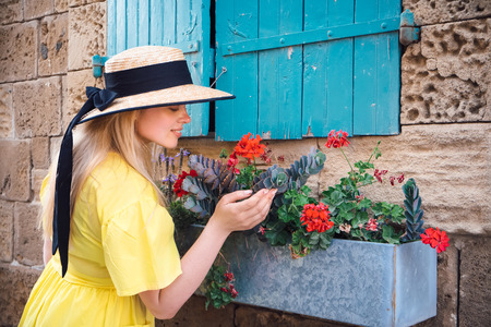 Beautiful blonde woman walking in yellow dress at Paphos old city with colorful door and house. Travel to Cyprusの写真素材