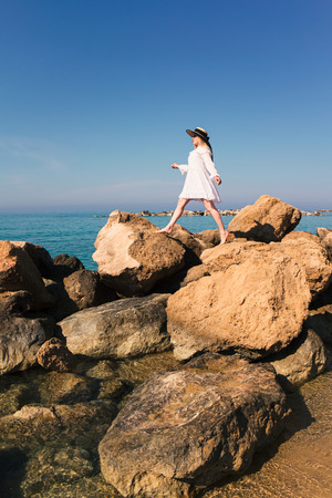 Beautiful blonde woman in white dress travel to Cyprus and relax near coral bay beach. Freedom summer conceptの写真素材