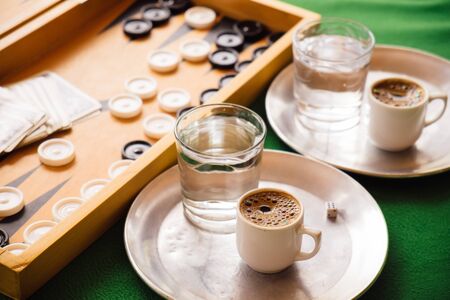 Cyprus traditional coffee on green table and board game at local cafe