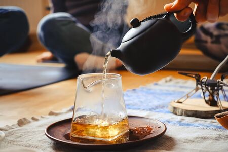 Master making chinese tea in traditional ceremony and pouring tea from teapot with vaporの写真素材