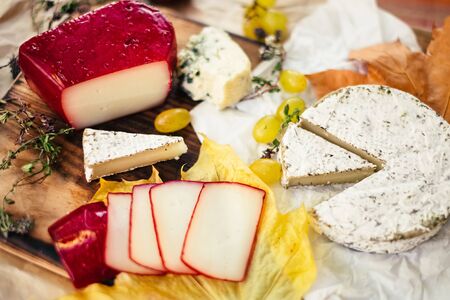 Set of aged Cheese, brie, camembert with fruit and herbal on wooden and craft paper backgroundの写真素材