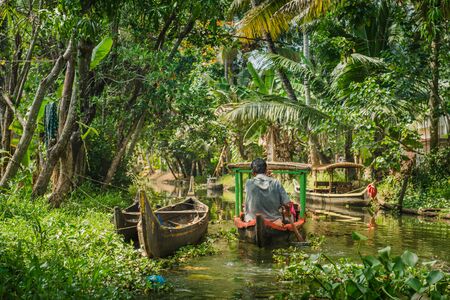Alleppey, India - January, 29, 2016: Small tourist boat on beautiful backwaters landscape with palm trees on background, Kerala, Indiaのeditorial素材