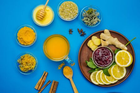Lemon and healthy tea with turmeric and honey for alternative medicine treatment and immunity system. Flat lay natural products on blue backgroundの写真素材