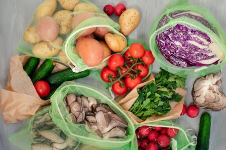 Vegetable in reusable bags on wood background, top viewの写真素材