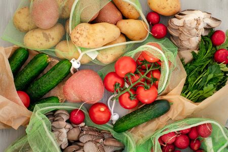 Vegetables in reusable net bags on grey wooden background, top view. Zero waste and eco friendly conceptの写真素材