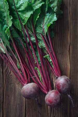 Close up of fresh beetroot with leaves on rustic wooden background, top viewの写真素材
