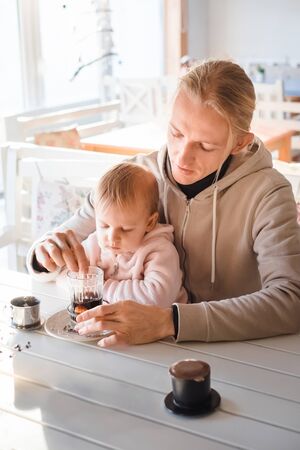 Happy young father and daughter spend time together in cafeの写真素材
