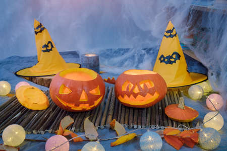 Two carved pumpkins with candles and decoration for Halloweenの写真素材