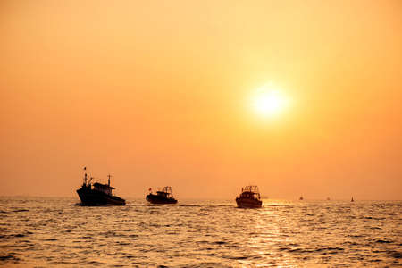 Fishin industry boats at sea back to port at sunsetの写真素材