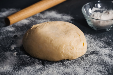 Handmade dough for bread on dark table background