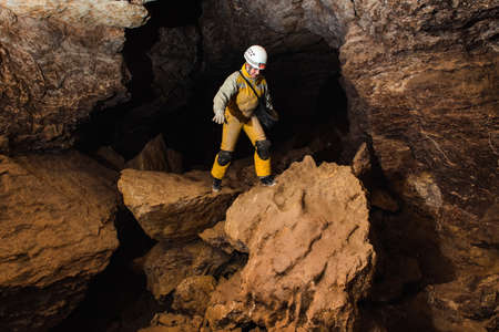 Tourist in camouflage suit explores caveの写真素材