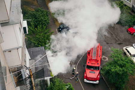 Fire truck near apartment building and extinguish fire in cityの写真素材