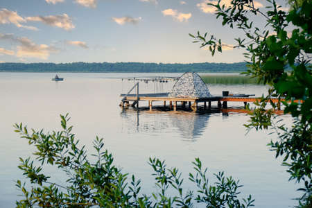Professional spinning fishing in the morning on the lake at sunsetの写真素材