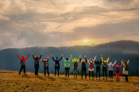 Group of friends with raised hands travel and enjoy natureの写真素材