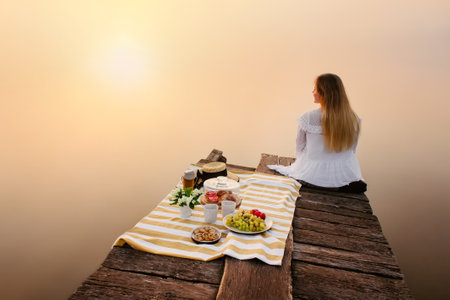 Woman enjoy nature near foggy lake at sunriseの写真素材