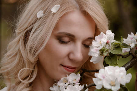 Woman portrait with eyes closed enjoying flowering springの写真素材