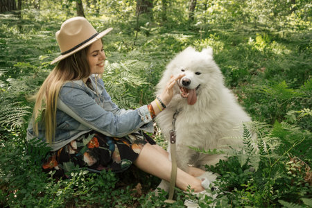 Woman spanding time with her fluffy dog samoyedの写真素材