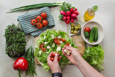 Preparing a vegetable salad with tomato and mozzarellaの写真素材