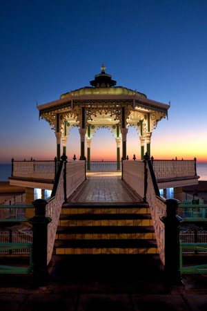 Brighton Victorian bandstand at sunset, also known as birdcage bandstand, the bandstand newly refurbished and is lit with white light and there is a beautiful sunset behind, newly refurbishedの写真素材