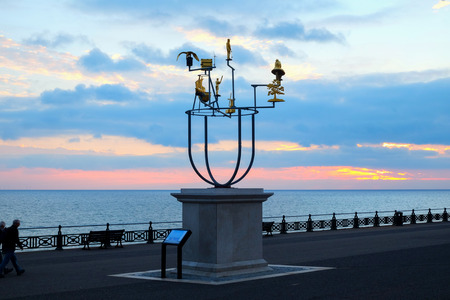 Artistâs plinth on Hove seafront promenade, Brighton, UK, with a delicate metal constellation sculpture on it behind is the promenade nd the sea at sunset, the sky is red and blue from the recently set sunの写真素材