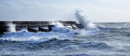 Dramatic stormy sea breaking against Brighton marina black stone harbour wall, spray and waves high in the air, rough sea, Brighton, East sussex, Ukの写真素材