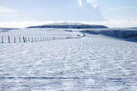 white Snow covered mount caburn, East Sussex, UK, long fences criss cross the top of the mountain, the whole image is mainly white.の写真素材