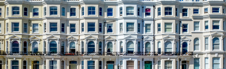 A line of white identical English regency terraced four storey houses with bay windows and balconies, Brighton, East Sussex, England, UK, United Kingdom,のeditorial素材