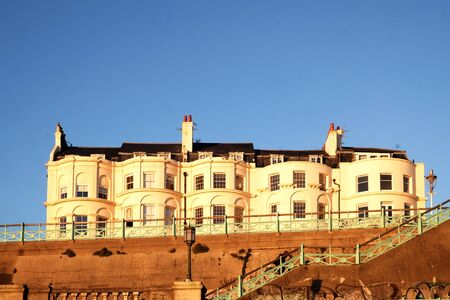 Brighton, Sussex, England, United Kingdom, 12-02-2019 UK, A typical row of white Geogian style terraced houses raised up on the seafront in Brighton, Sussex, England,Uk, an example of the housing market in demand in the south of England. copy space in theのeditorial素材