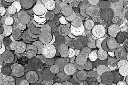 UK currency, hundreds of British copper and silver colored coins randomly piled ontop of each other, one pound coins, fifty pence, twenty pence, two pence, one pence,  の写真素材
