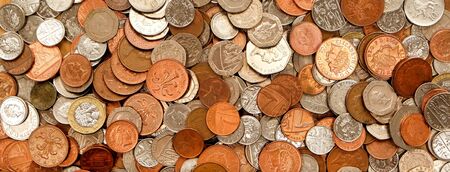 UK currency, hundreds of British copper and silver colored coins randomly piled ontop of each other, one pound coins, fifty pence, twenty pence, two pence, one pence,  の写真素材