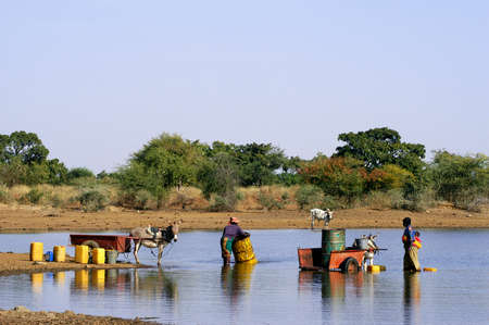 filling and transportation of water bottles at lake is for women to irrigate cropsのeditorial素材