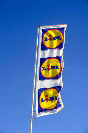 Flags in the colors of Lidl supermarket on the harbor of Grau-du-Roi windy dayのeditorial素材
