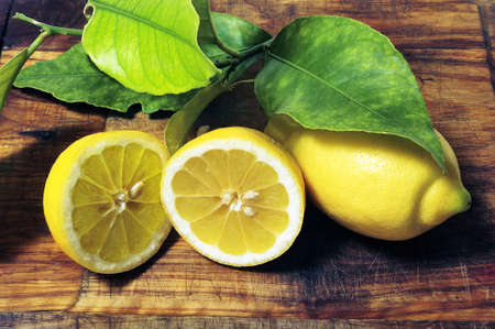lemons with leaves on a cutting board ready to BE cookedの写真素材