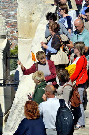 Of tourist visitors to the Basilica of Notre Dame de la Garde in Marseille and a guide explains the history of the placeのeditorial素材