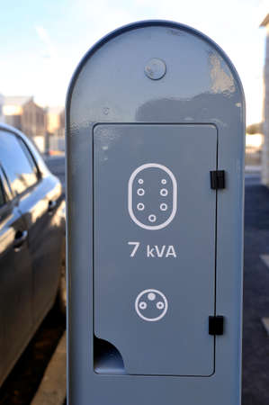 Electric car charging station at the foot of a new buildingの写真素材