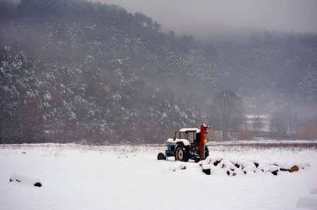 Tractor left in the middle of a snowy field which is rare in the south of Franceの写真素材