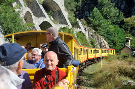The travelers of the little yellow train of the Pyrenees in the wagon in the open airのeditorial素材