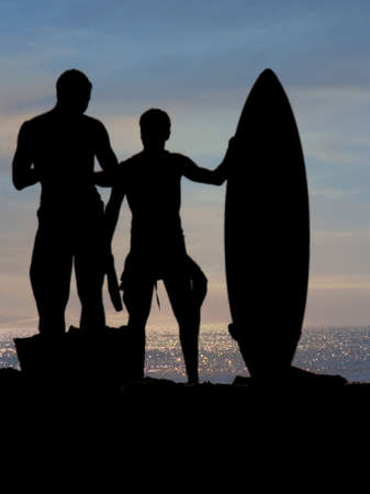  surfers watching the sun go down on a Portugal beach                                    の写真素材