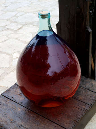 A large bulb shaped bottle on display outside a traditional building on the Island of Ithaca in Greeceの写真素材