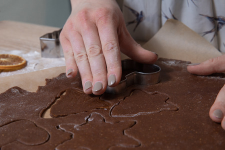 Cutting Christmas cookies, baking gingerbread men, making christmas cookie , homemade traditional ...