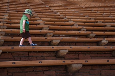 Little Boy Walking Along Stadium Seats