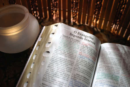Open page of Bible with candle lighted