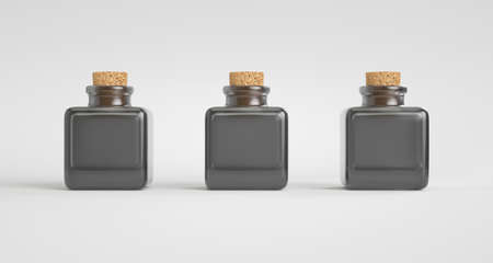 Three black translucent glass bottles with cork stoppers. Light backgroundの写真素材