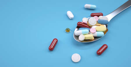Tablespoon of pills. Spoon full of capsules (blue background).